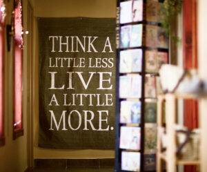 Wall scroll with the words 'Think a little less. Live a little more.'