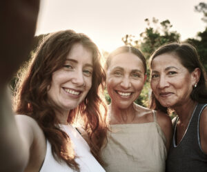 Three women smiling for a picture taken together