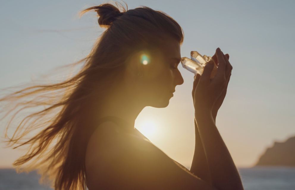 Woman holding a crystal to her forehead