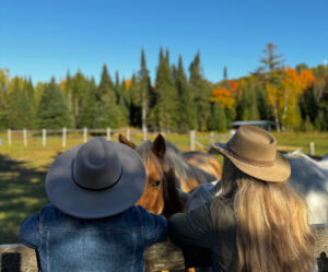 Two woman standing with horses