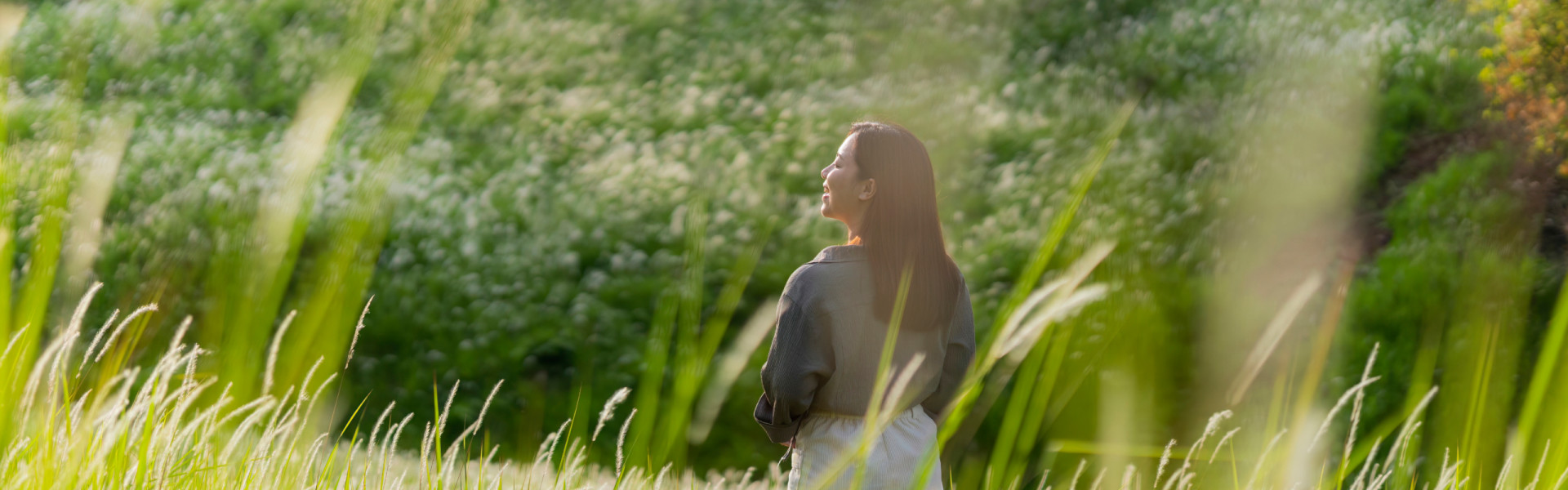Woman smiling while standing in a grass field