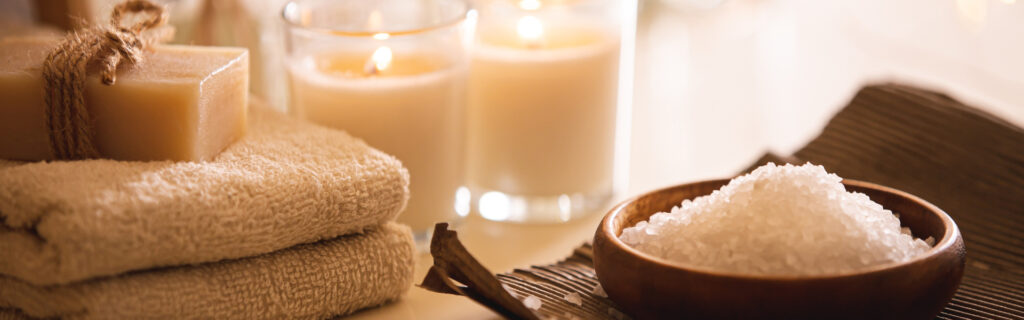 Close up of bowl of salt beside spa essential items