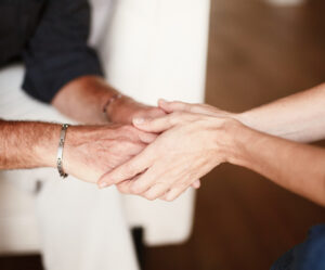 Two people holding hands gently